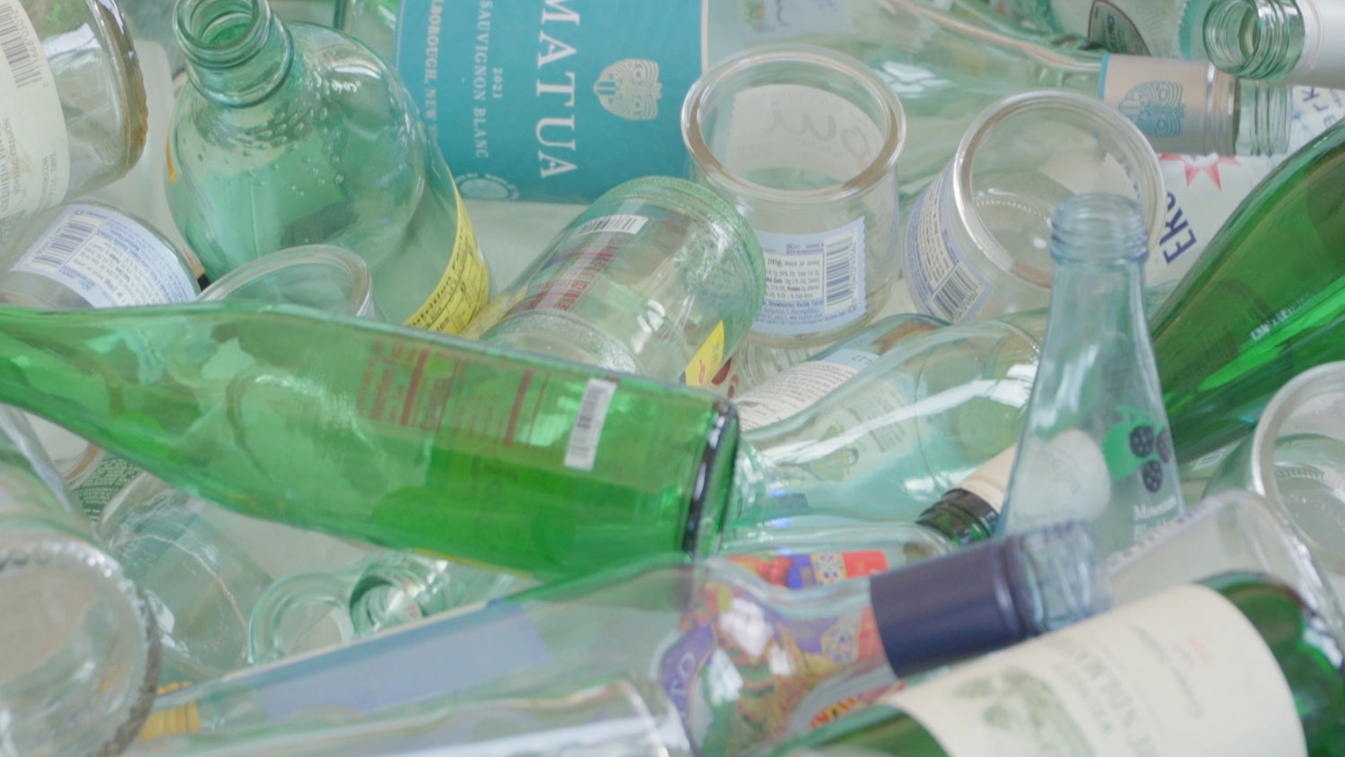 Overview shot of recycled glass bottles that are clear, green, and blue