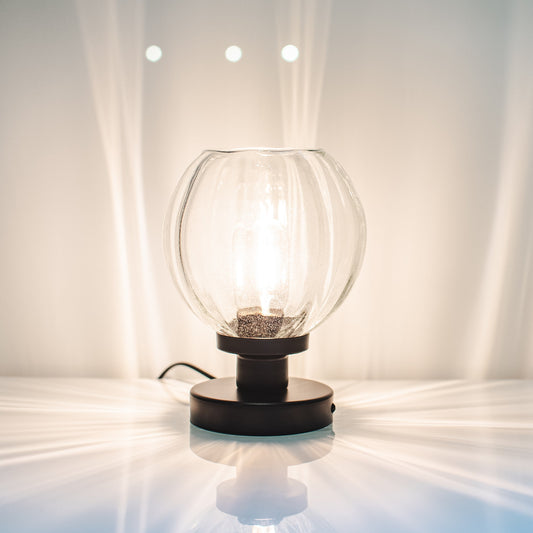 Glowing table lamp on a white surface with a neutral background