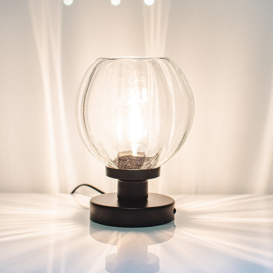 Glowing table lamp on a white surface with a neutral background