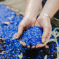 person holding blue recycled glass sand