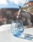blue short glass being filled with water from pitcher