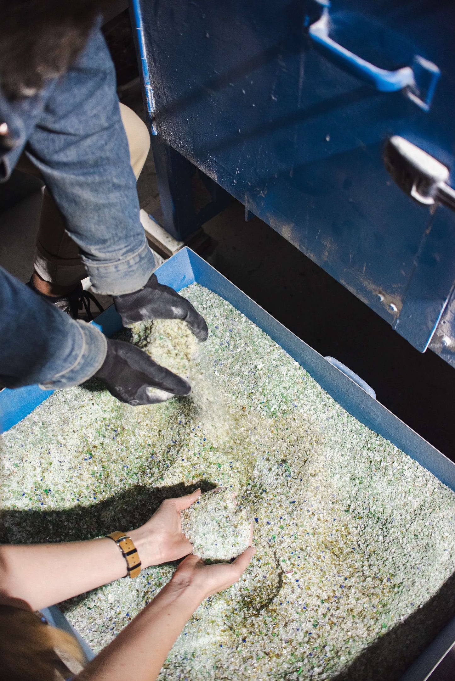 recycled glass sand, people touching it with their hands