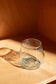 light blue short glass with red background