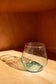 light blue short glass with red background