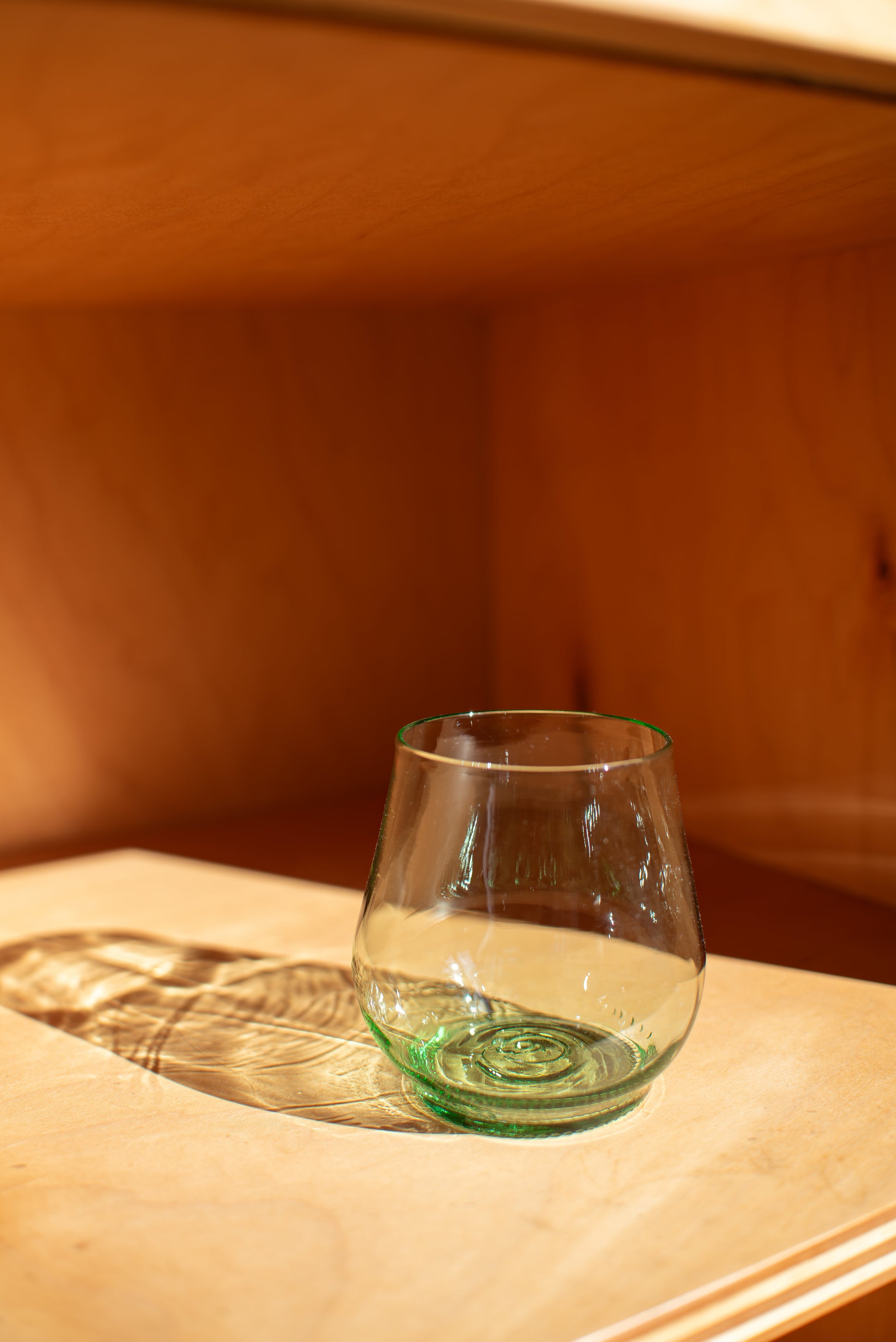 light green short glass with red background