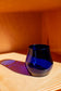 blue short glass with red background
