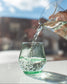 short glass being filled with water from pitcher