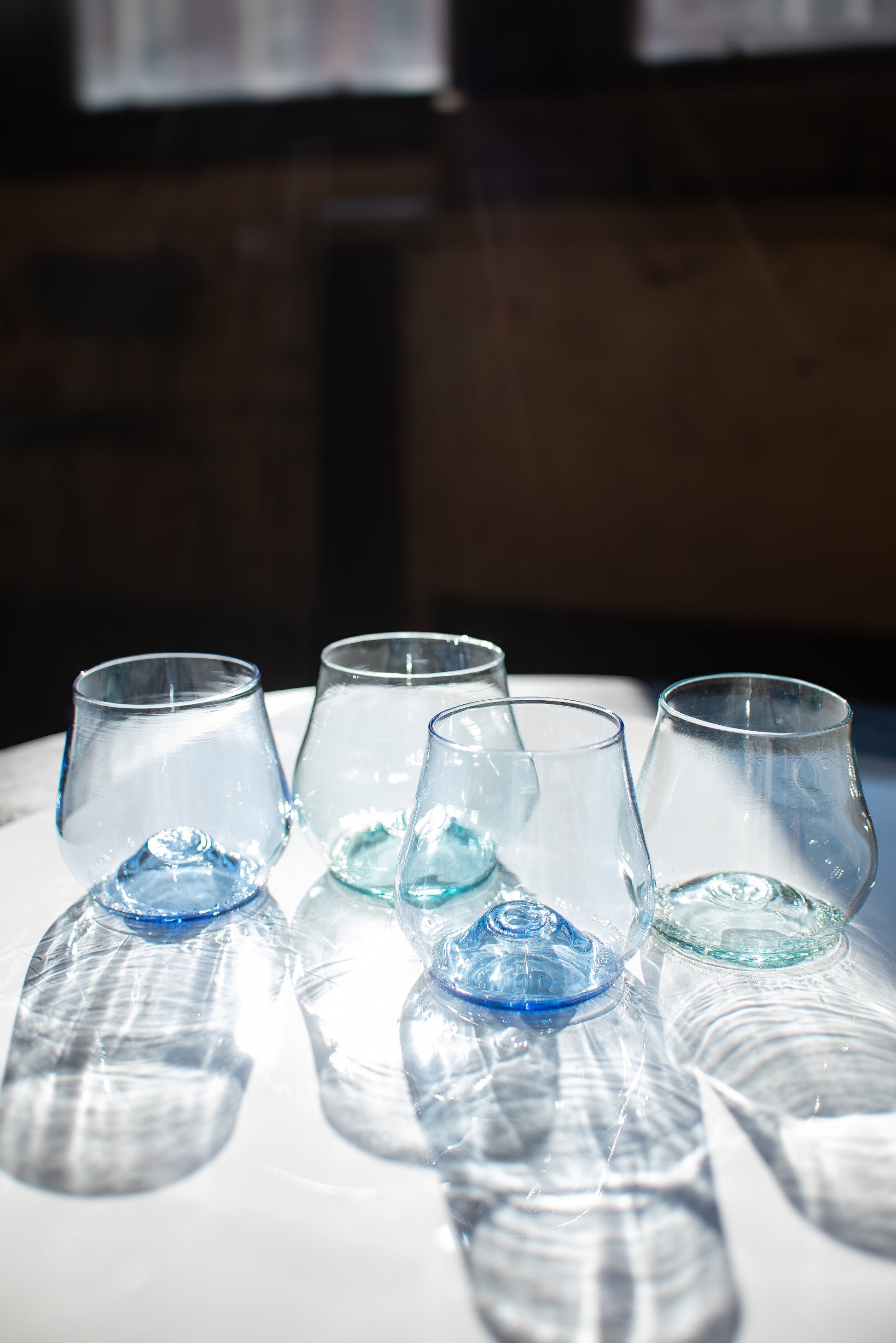 a set of short glass cups with a dark background on light table
