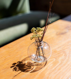 Clear recycled bud vase with dried foliage