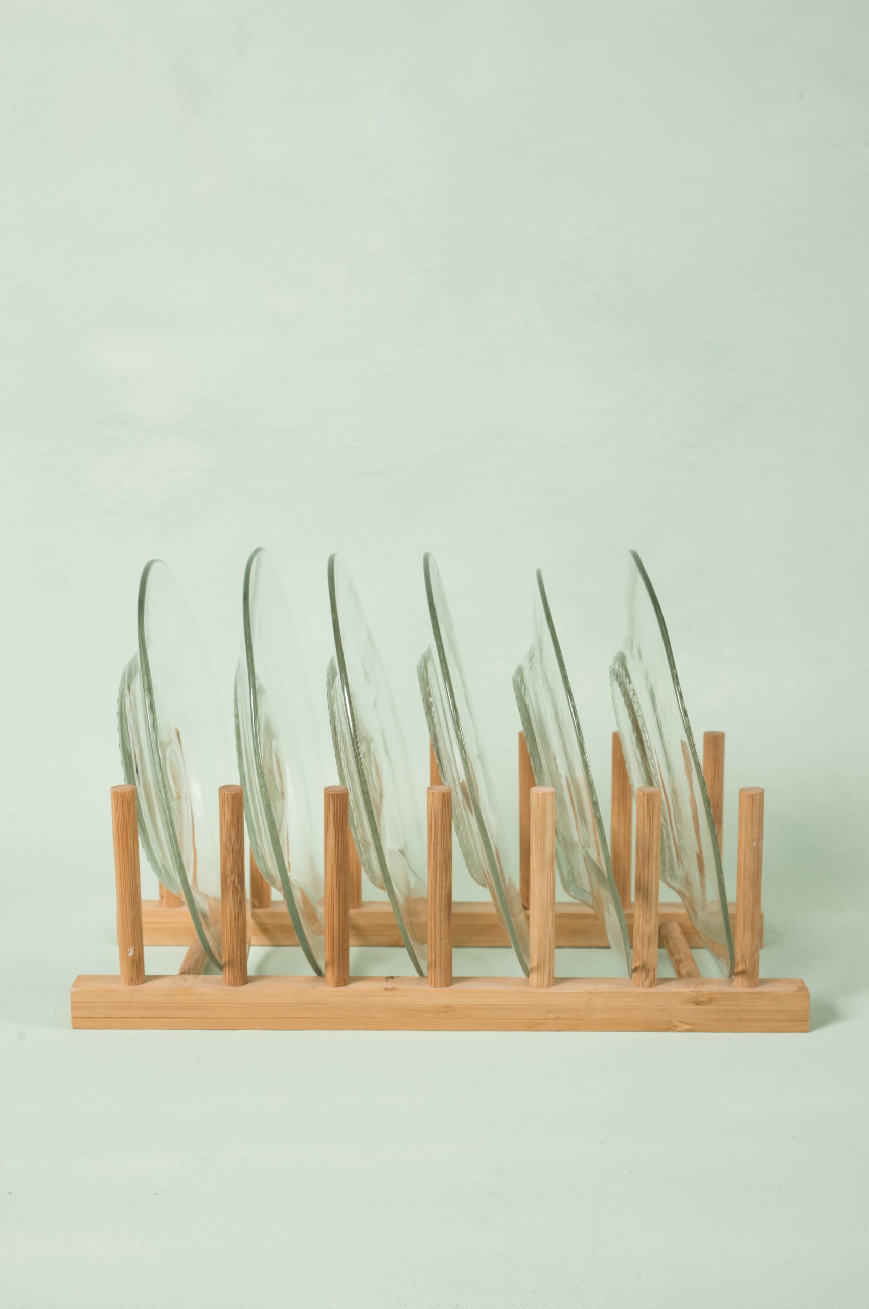 set of six clear appetizer side plates made from recycled glass, on wooden rack