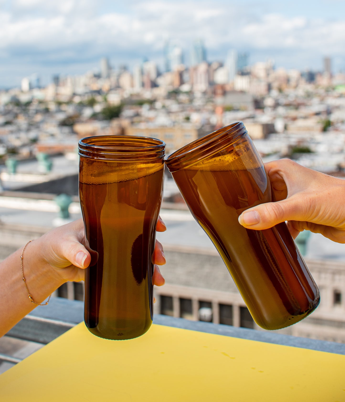 Recycled amber draught glasses cheers with Philadelphia skyline in background