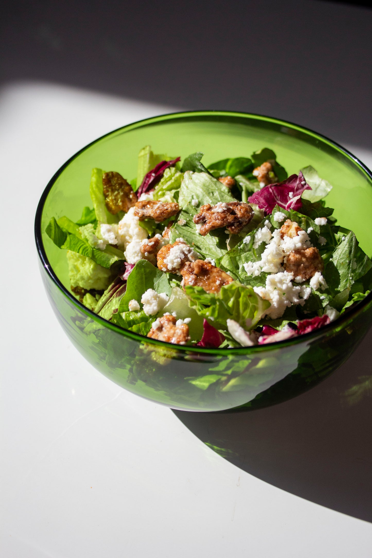 Medium emerald serving bowl made from a recycled bottle. The bowl is full of salad. 