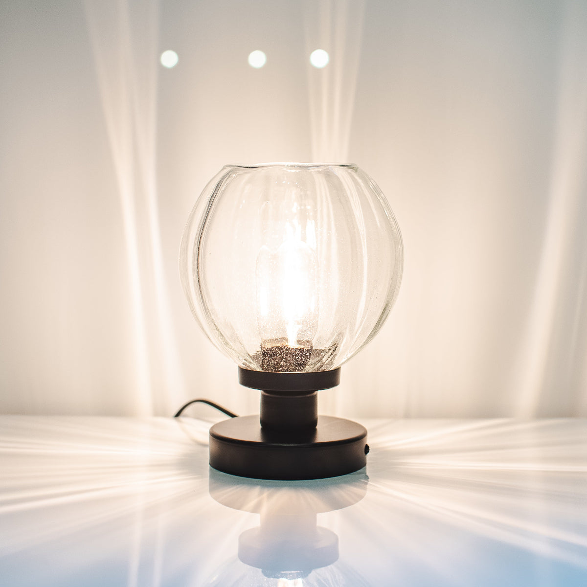 Glowing table lamp on a white surface with a neutral background