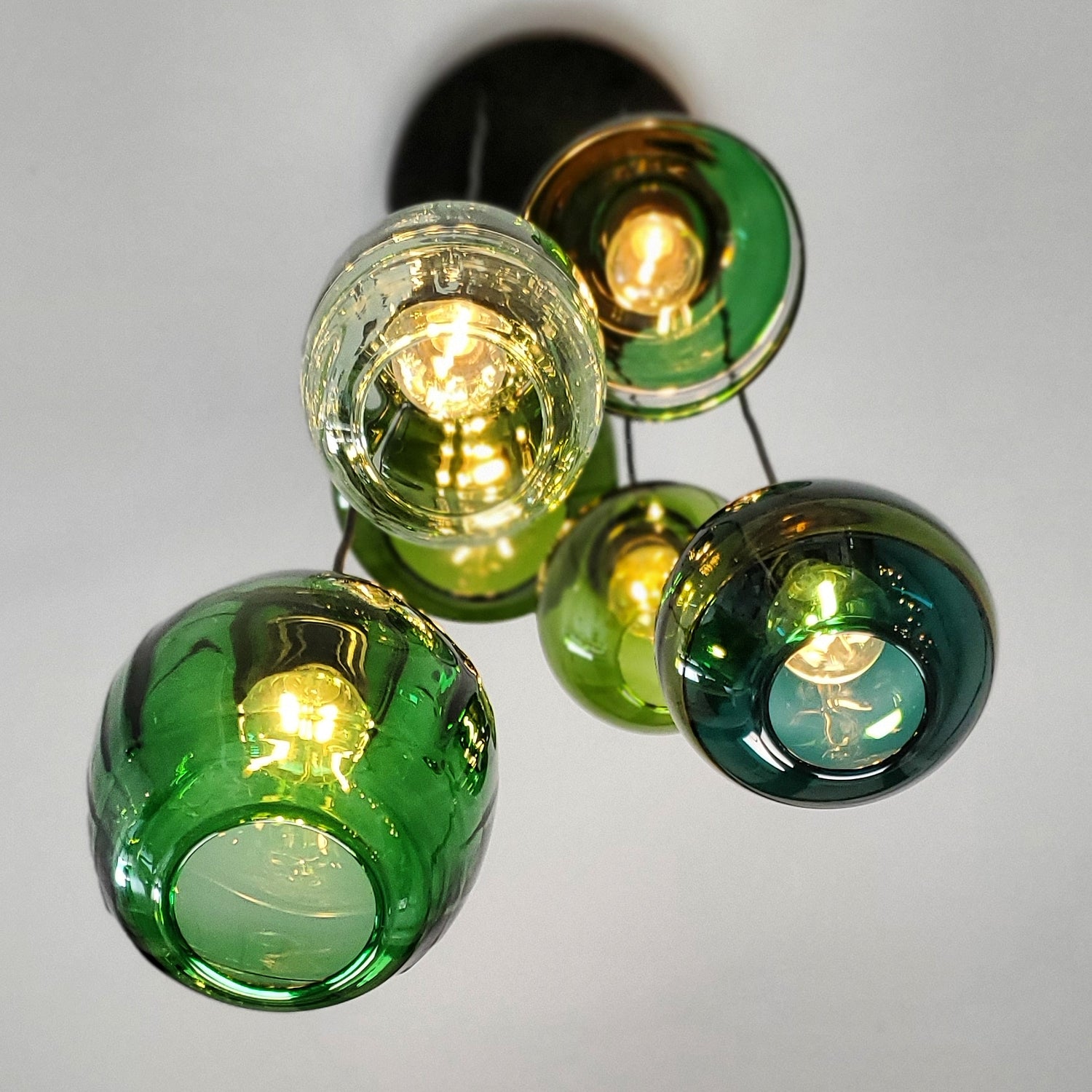 A chandelier hanging from the ceiling with different shades of green