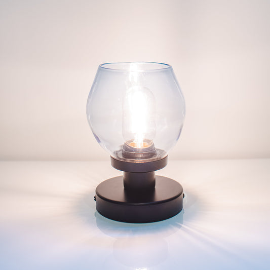 Small glass lamp with black base on a white surface