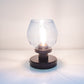 Small glass lamp with black base on a white surface