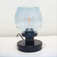 Table lamp with a clear glass shade and black base on a white background
