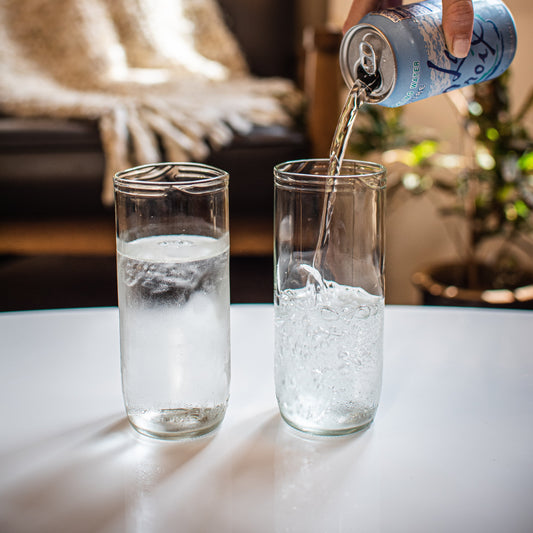 two pint glasses, one of them being poured into