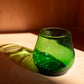 green short glass with red background