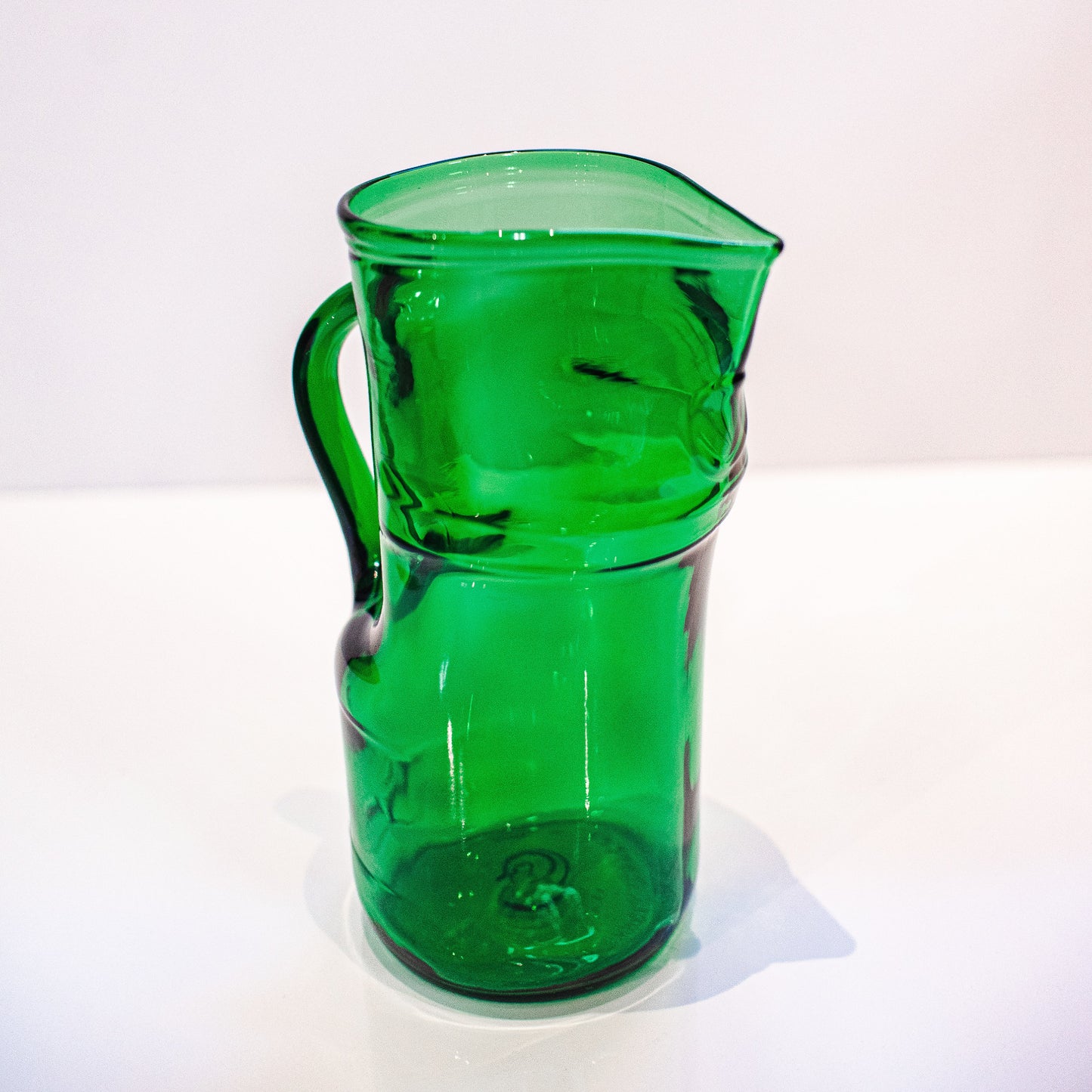 green glass pitcher on white background