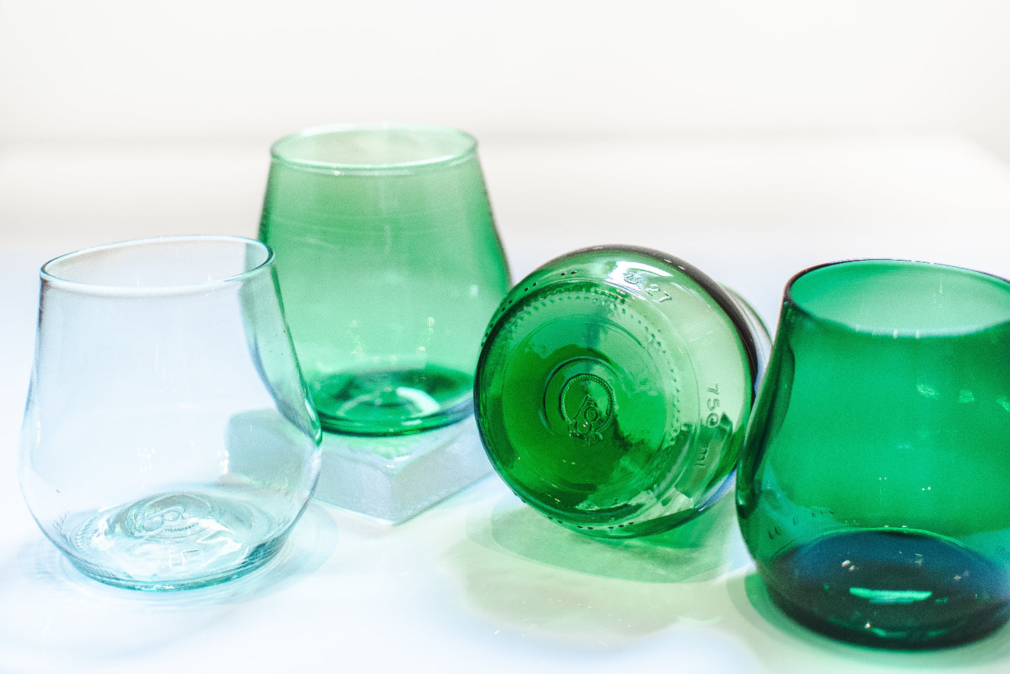 Set of green glass tumblers on a white background