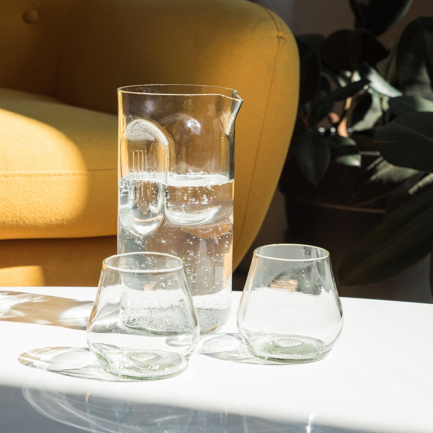 clear pitcher and wine glasses made from recycled glass