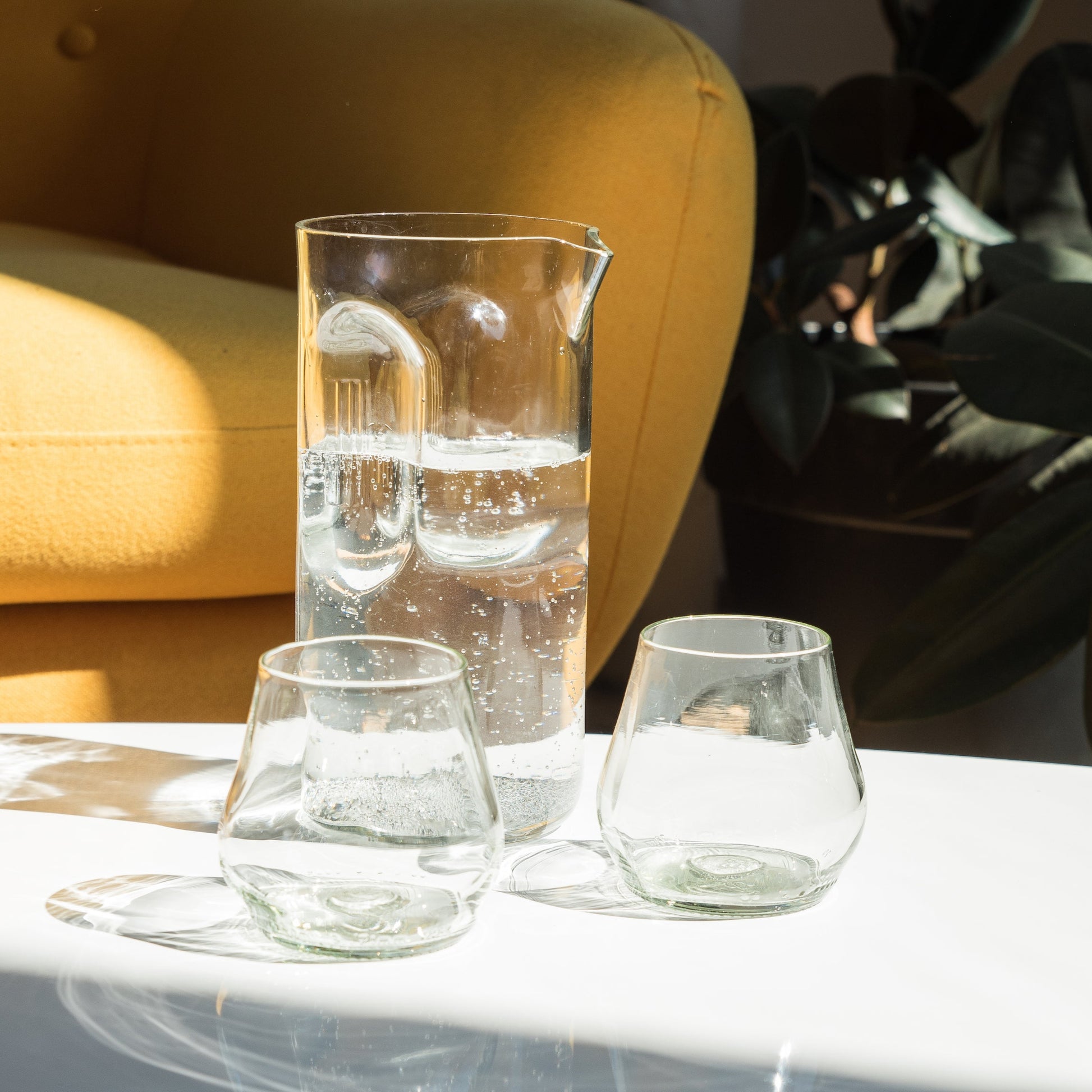 clear pitcher and wine glasses made from recycled glass