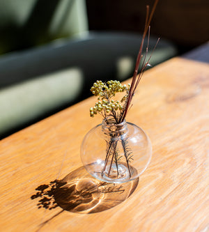 Clear recycled bud vase with dried foliage 
