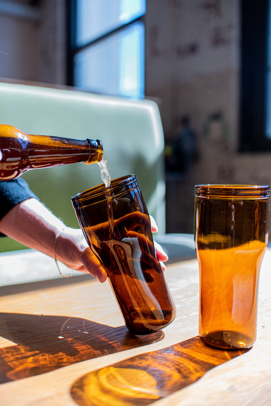 beer being poured into recycled amber draught glasses