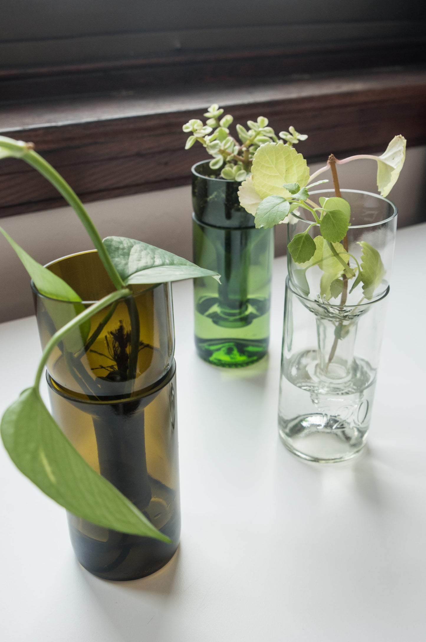 amber, emerald, and clear self-watering planters made from recycled glass