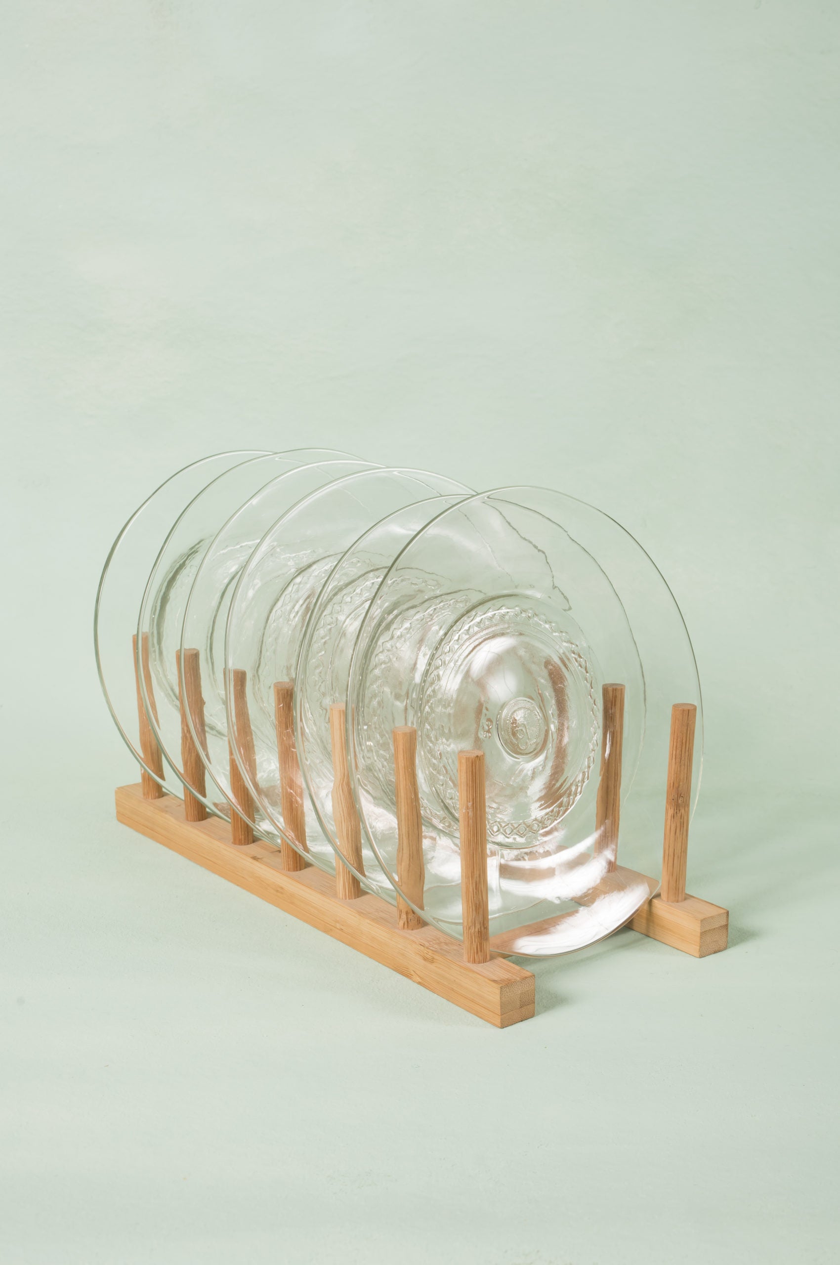 set of six clear appetizer side plates made from recycled glass, on wooden rack